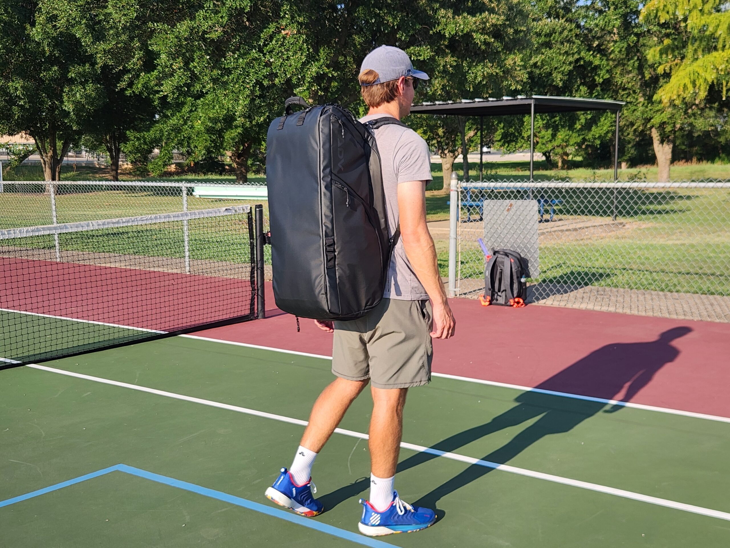 Person wearing the ADV Tennis Bag Pro v3 on the tennis court