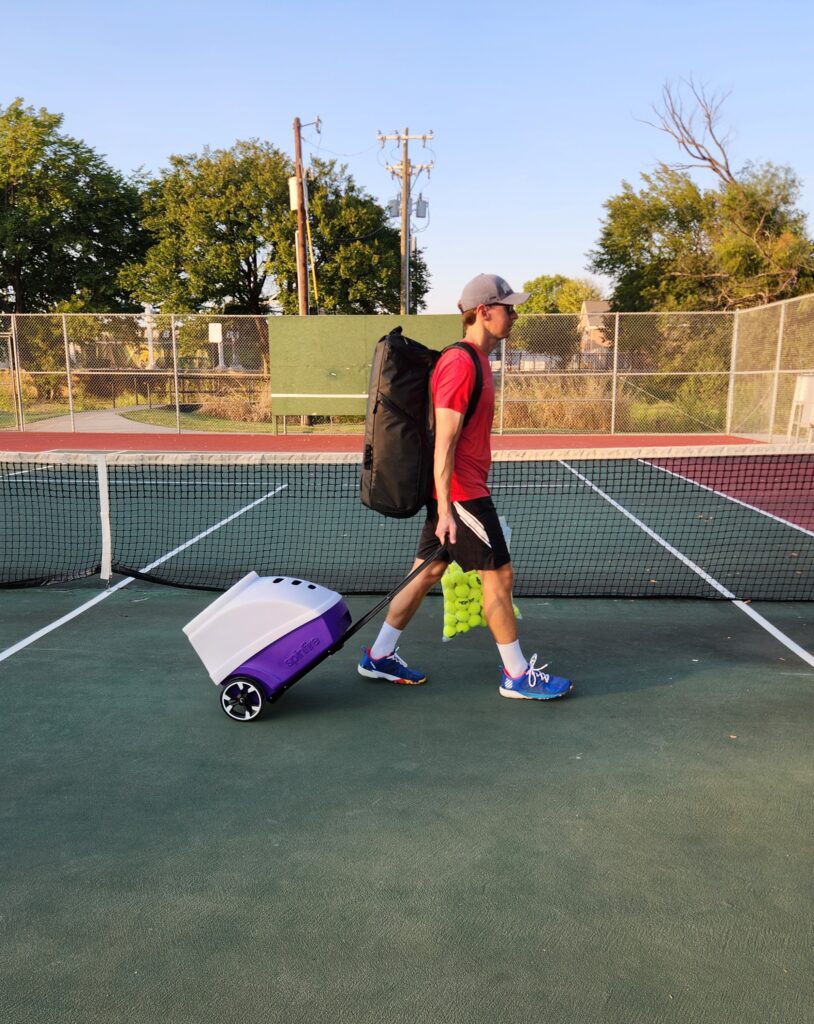 Rolling the Spinfire Pro 2 tennis ball machine accross the court