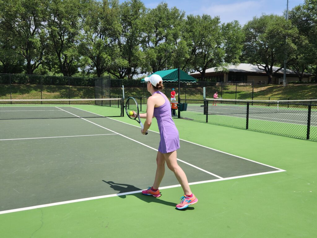 Woman serving with a new tennis racquet